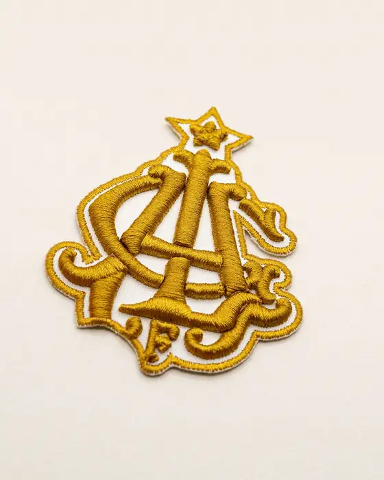 Monograma dorado bordado en relieve 3D con corte a forma