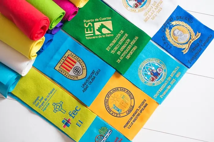 Becas bordadas de colores con escudos de institutos y facultades