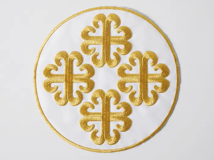 Medallón blanco con cruces bordadas en hilo dorado