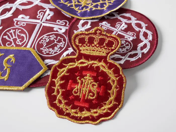 Escudos cofrades bordados con corona dorada y anagrama IHS