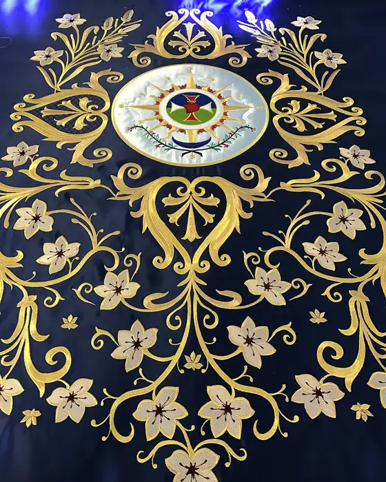 Bordado en oro de flores y volutas sobre terciopelo azul con medallón central