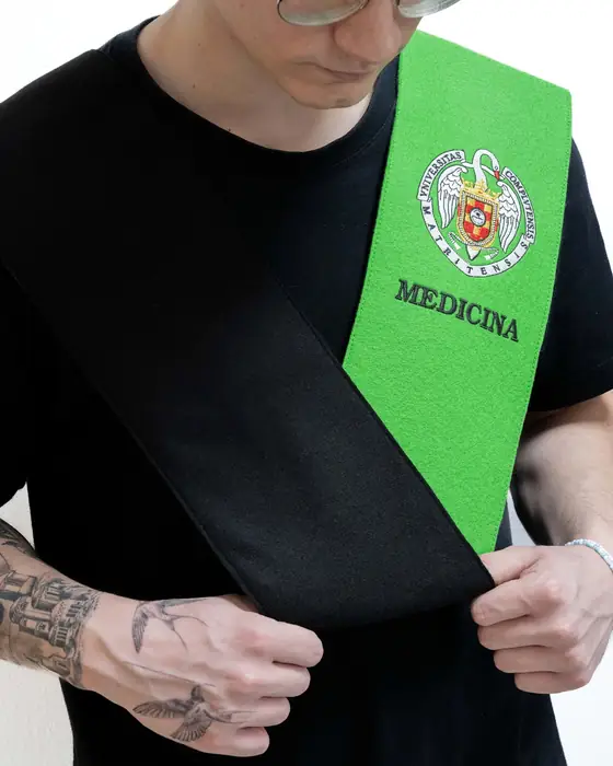 Beca doble negra y verde de Medicina, sujeta con las manos