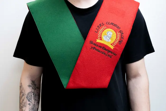 Beca doble verde y roja con escudos bordados, puesta