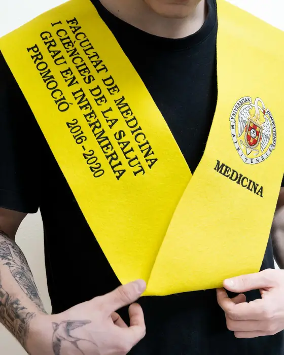 Beca amarilla de la facultad de Medicina puesta, con escudo bordado