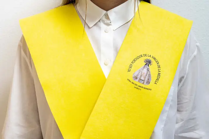 Beca amarilla con escudo serigrafiado sobre camisa blanca