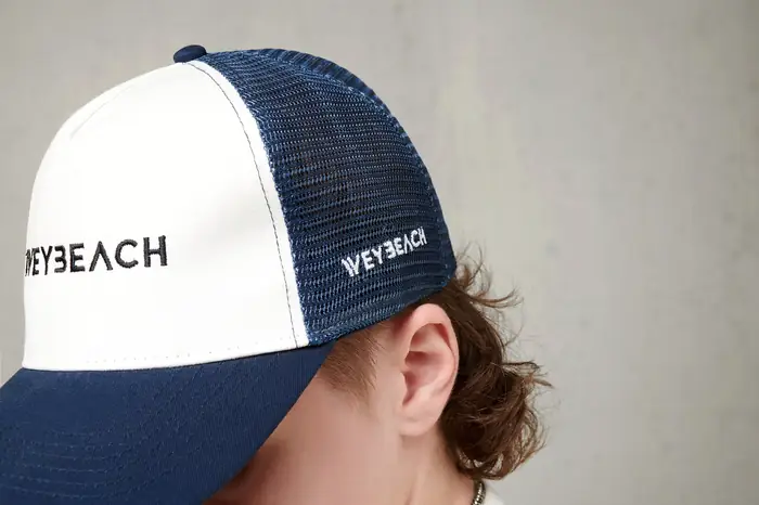 Gorra trucker azul y blanca con logotipo bordado, puesta