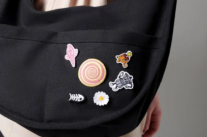 Bolso negro con pines bordados pequeños, al hombro