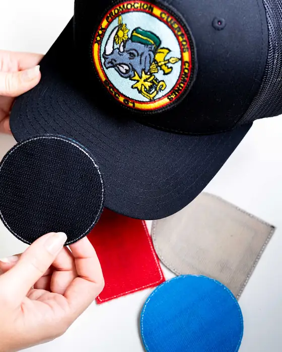 Mano quitando el parche de velcro de una gorra azul marino
