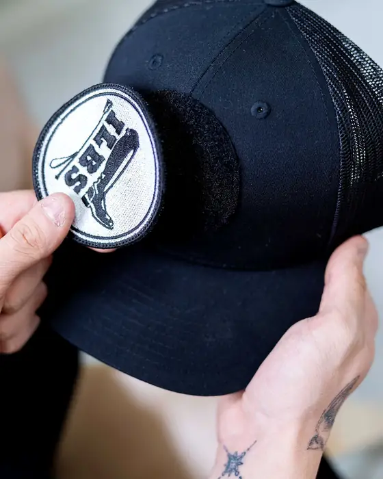 Manos colocando un parche de velcro en una gorra negra