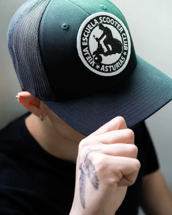 Gorra verde con parche de velcro de un club, puesta