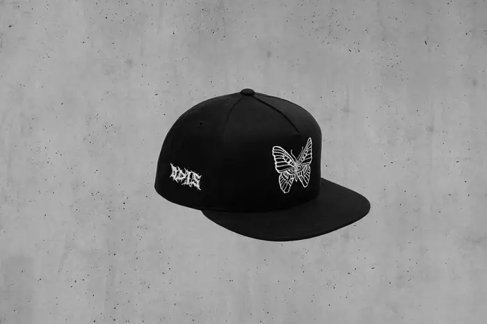 Gorra negra con mariposa bordada en hilo blanco