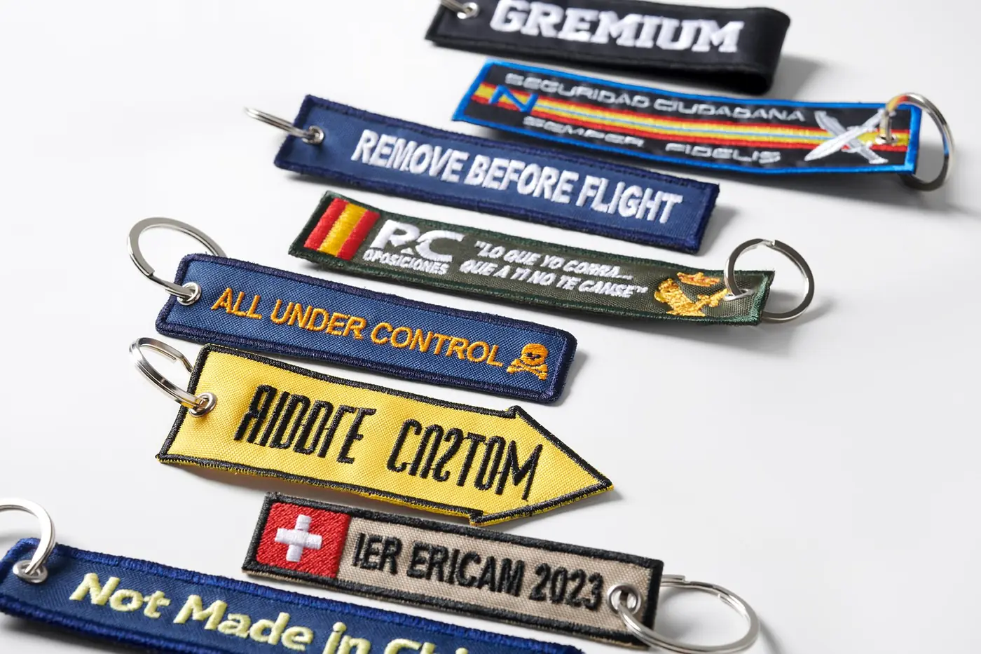 Llaveros bordados personalizados con anilla metálica sobre mesa de taller