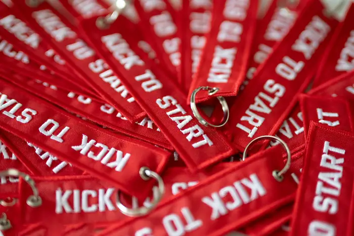 Tirada de llaveros bordados rojos Kick to Start