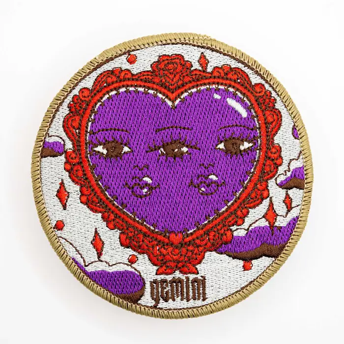 Parche bordado ilustrado con corazón morado y detalle de puntada fina