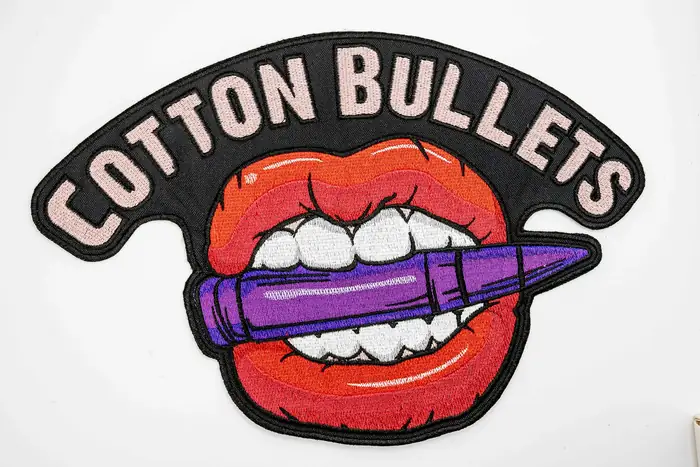 Parche bordado Cotton Bullets con labios rojos y letras en arco