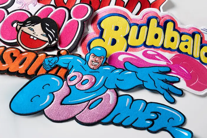 Detalle de parches de fieltro con bordado brillante en azul y rosa