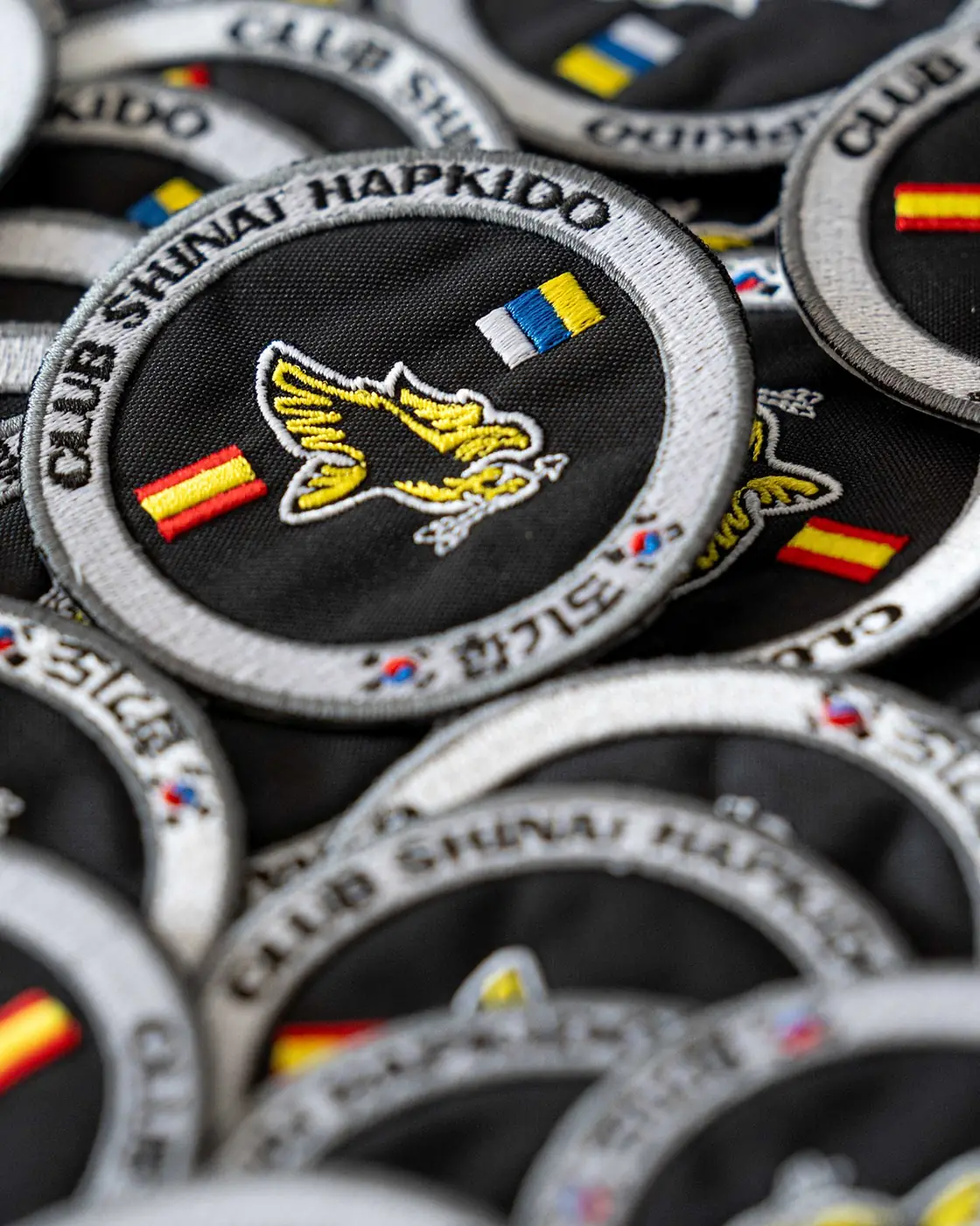 Escudo bordado en hilo dorado sobre equipación azul marino
