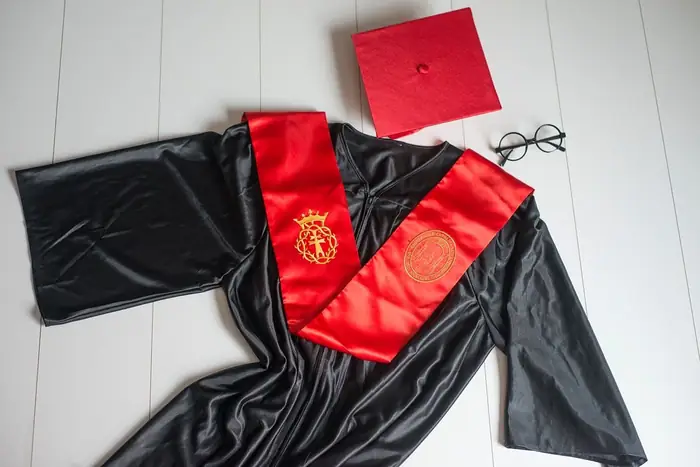 Conjunto de graduación: toga negra, beca roja bordada y birrete