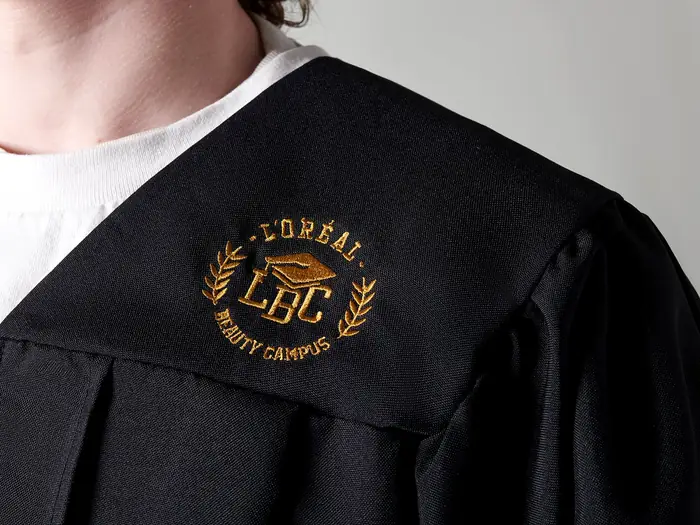Toga negra con escudo bordado en dorado a la altura del pecho
